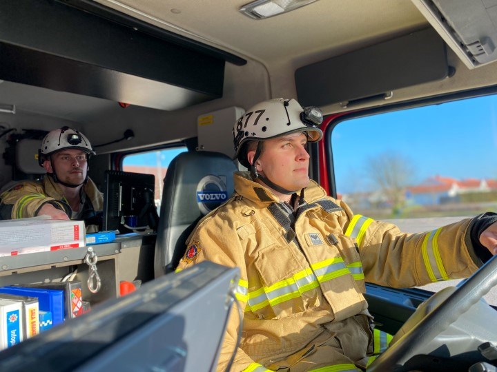 två brandmän i en brandbil 