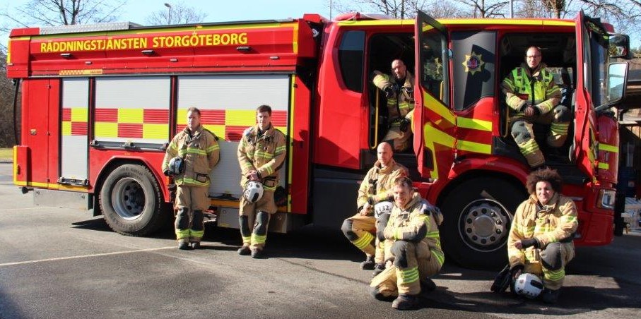 flera brandmän framför en brandbil 